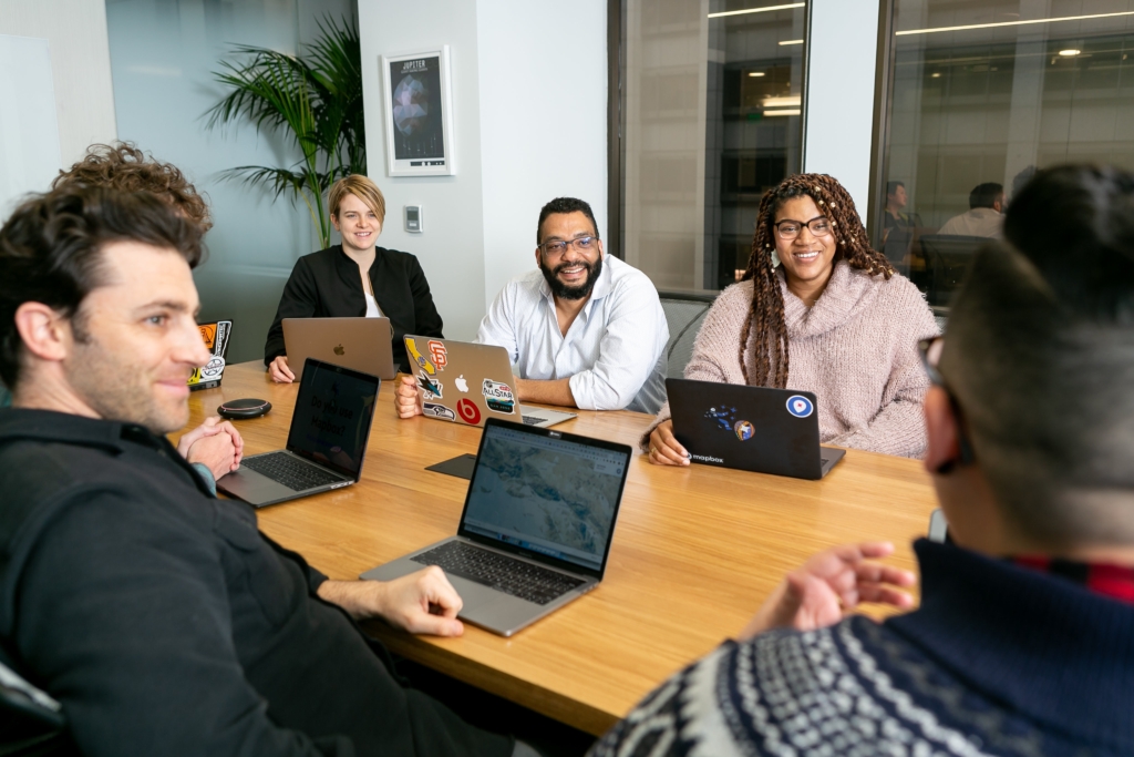 Image of team members at a conference table collaborating